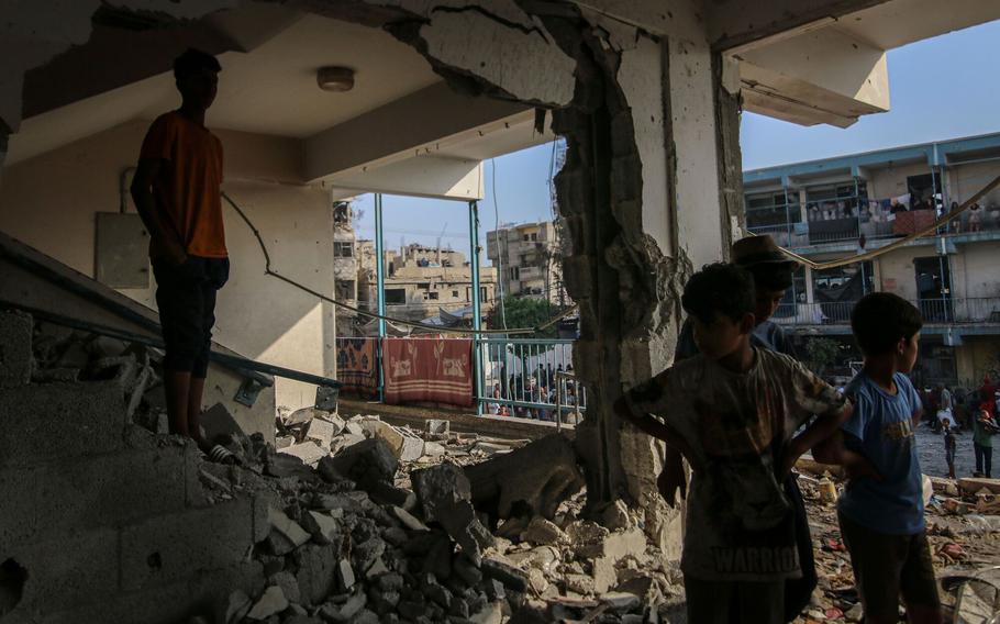 Palestinians inspect the damage to a school complex for displaced Palestinians, operated by the United Nations Relief and Works Agency (UNRWA), following an Israeli strike at the Nuseirat refugee camp in central Gaza, on Thursday, June 6, 2024. 