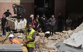 Residents react as rescuers sift through the rubble, searching for people still missing at the site of Friday's Israeli strike in Beirut's southern suburbs, Monday, Sept. 23, 2024. (AP Photo/Hassan Ammar)