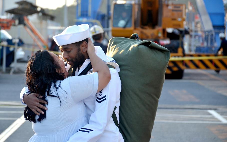 A USS Blue Ridge sailor kisses his partner moments after stepping off the ship at Yokosuka Naval Base, Japan, Tuesday, Aug. 20, 2024.