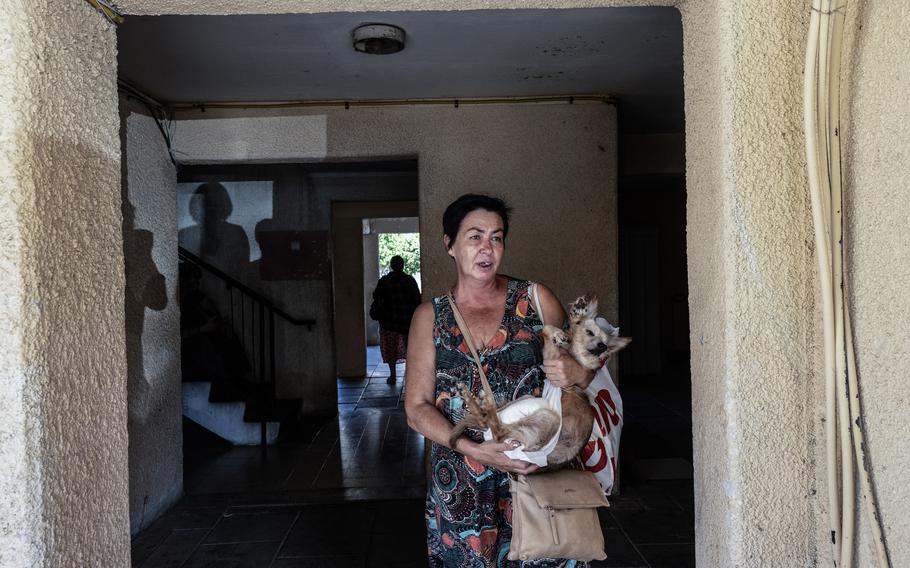 Elena Kotz, 54, holds her dog and takes shelter on the bottom floor of her residential building during air sirens in Kiryat Bialik, Israel