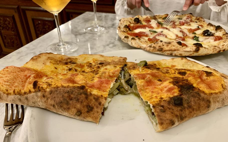 A ripieno, or stuffed pizza, at Antica Pizzeria Chiaia, features escarole, olives, capers, anchovies and cheese baked in the restaurant's signature pizza dough. A version of Naples' famed Margherita pizza, top, includes San Marzano tomatoes. 