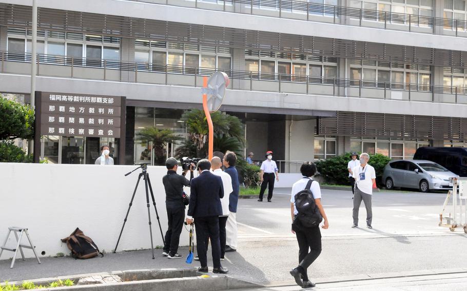 Reporters covering an airman’s sexual assault and kidnapping charges stand outside Naha District Court on Okinawa, Friday, Aug. 23, 2024.