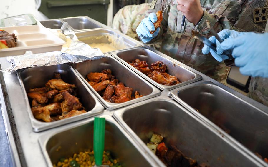 A culinary specialist checks the temperature of chicken wings.