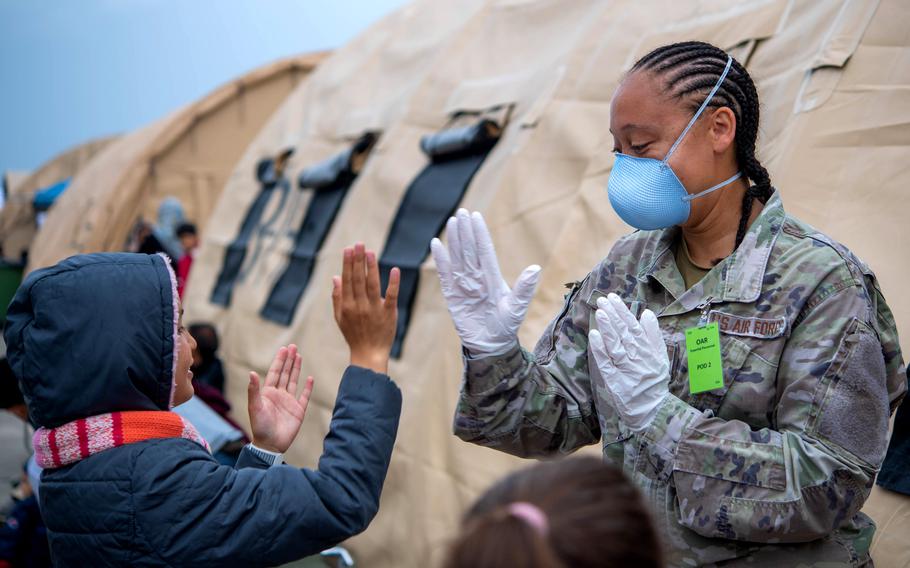 Air Force Tech. Sgt. Cecile King plays with children during Operation Allies Refuge at Ramstein Air Base, Germany, on Sept. 10, 2021. Flights carrying Afghan evacuees to the U.S. are still on hold because of four diagnosed cases of measles among evacuees who recently arrived in the U.S., military officials said Monday.
