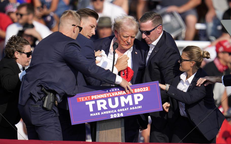 Donald Trump is helped off a stage at a campaign event after being shot at