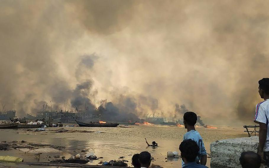 People looking at flames rising after an airstrike