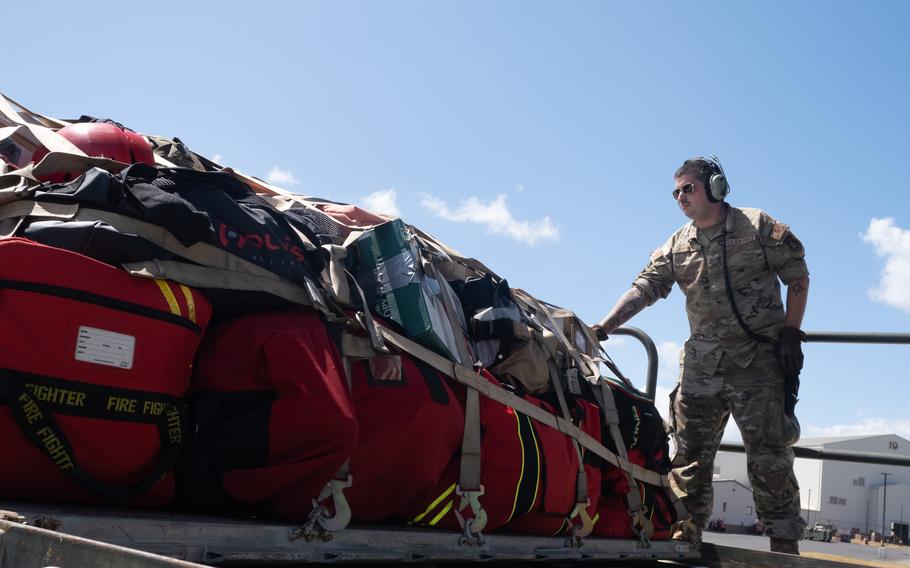 Staff Sgt. Trevor Connors, 154th Aircraft Maintenance Unit, loads firefighters' gear and supplies onto a C-17 Globemaster III, Aug. 10, 2023, at Joint Base Pearl Harbor-Hickam, Hawaii. National Guard and active-duty troops are providing security and searching for remains at Lahaina, the historic town in Hawaii nearly destroyed by wildfire a week ago, according to Hawaii Guard Brig. Gen. Stephen Logan.