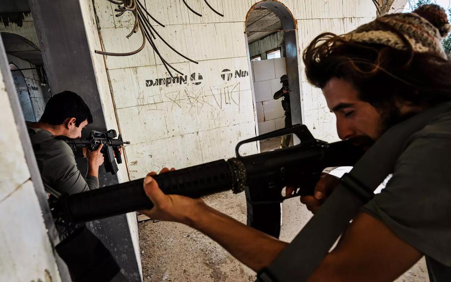 Reservist soldiers, settlers and volunteers from Israel and the United States take part in weapons training Thursday, Nov. 9, 2023, in a building under construction in Mitzpe Yair, an Israeli settlement in the occupied West Bank.