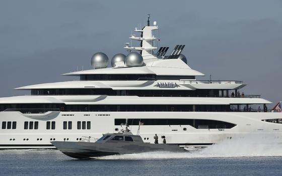 A U.S. Navy boat speeds by the $300 million dollar, 348-foot luxury ...