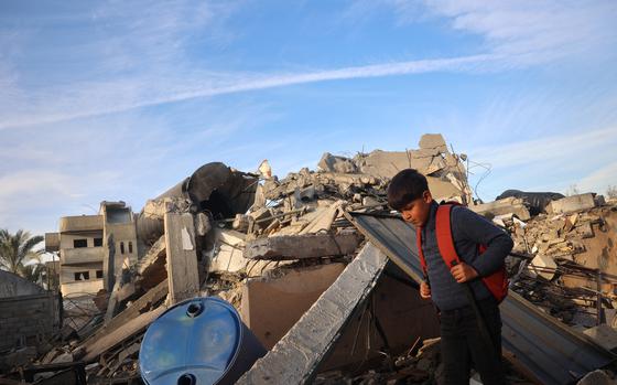 A boy walks past a destroyed building in the aftermath of an Israeli strike at Deir el-Balah in the central Gaza Strip, on Jan. 15, 2025, amid the ongoing war between Israel and the militant group Hamas. (Eyad Baba/AFP/Getty Images/TNS)