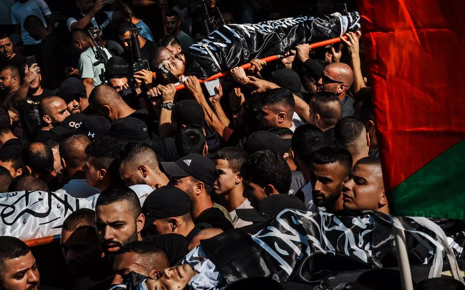 Thunderous gunfire and sorrowful praise for God punctuated a mass funeral for 14 Palestinians killed after Israeli forces raided the refugee camp in Jenin, in the occupied West Bank, on Nov. 10, 2023.