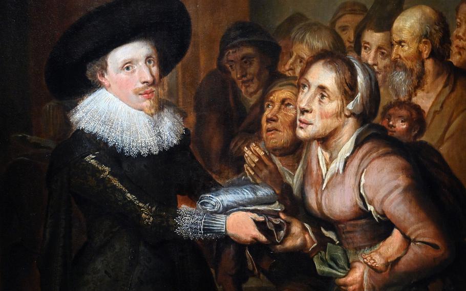 A detail photo of the warden an almshouse distributing clothing to the poor. The painting by an unknown artist, but possibly David Vinkboons, is on display at the exhibit “Rembrandt’s Amsterdam. Golden Times?” at the Städel in Frankfurt.