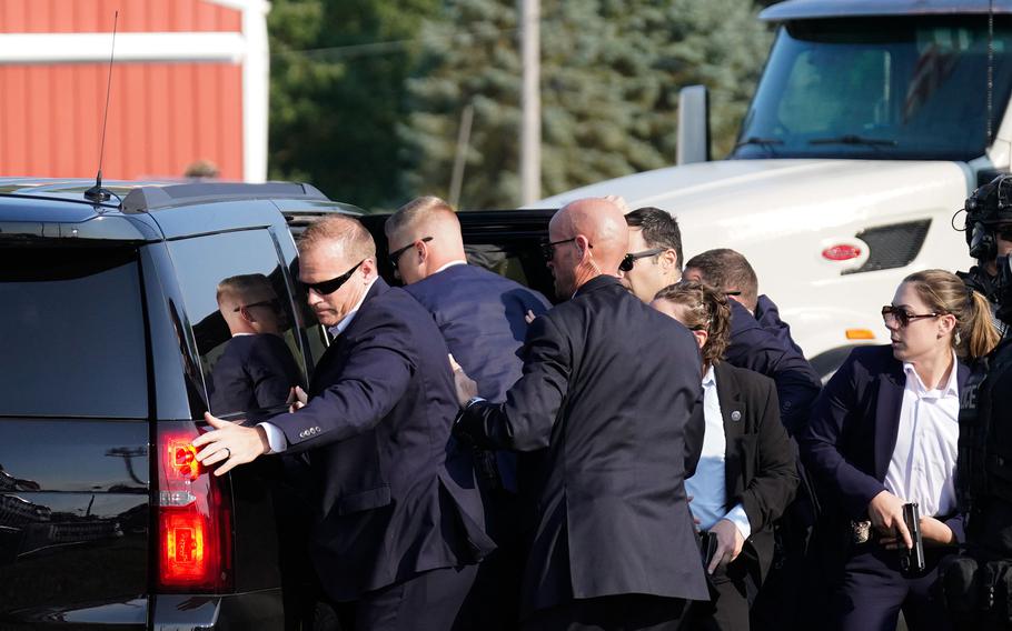 Members of Secret Service assist former president Donald Trump into a vehicle on Saturday, July 13, 2024. 