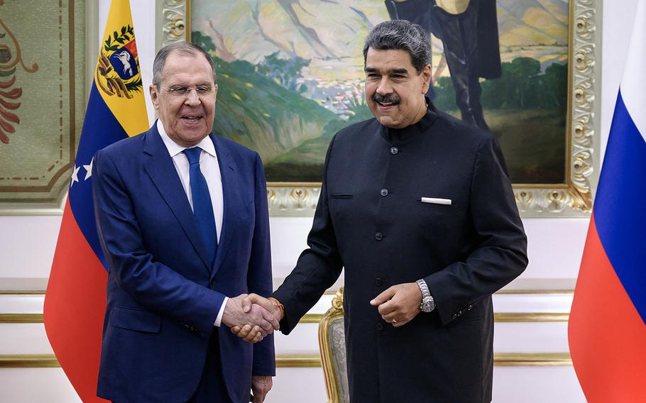 Venezuela’s President Nicolas Maduro (right) shakes hands with Russian Foreign Minister Sergei Lavrov upon his arrival at the Miraflores Presidential Palace in Caracas on Feb. 20, 2024. 