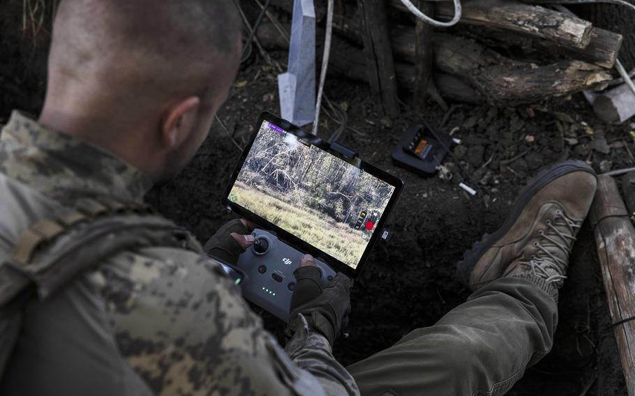 Victor Stelmakh, head of an attack drone unit in the 68th Jaeger Brigade, rests a Starlink-connected phone on his body armor to communicate with soldiers while piloting a drone in the Luhansk region on Sept. 1, 2023.