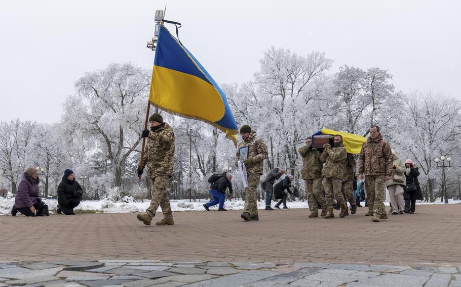 Ukrainian soldiers carry the national flag and the coffin of an actor and fallen soldier, Nov. 27, 2024.