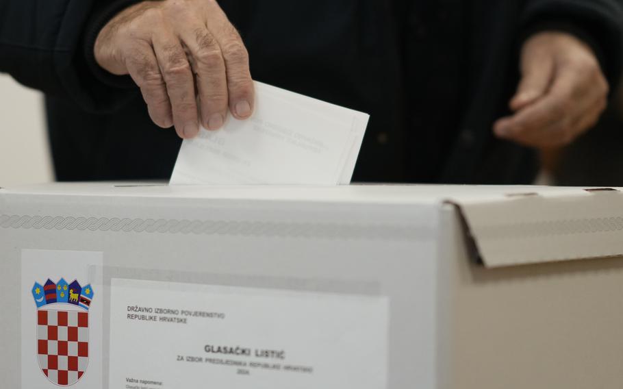     A man throws his ballot into a ballot box during the presidential election at a polling station in Zagreb, Croatia.