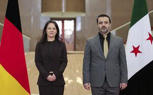 This photo released by the official Syrian news agency SANA, shows Germany's Foreign Minister Annalena Baerbock, left, and Syrian Foreign Minister Asaad Hassan al-Shibani, pose for a photograph in Damascus, Syria, Thursday, March 20, 2025. (SANA via AP)