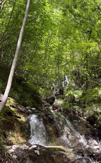 The waterfall about halfway along the Lake Mis-Val Falcina trail in Italy's Dolomiti Bellunesi National Park offers a place for refilling water bottles or cooling down in the shade. 