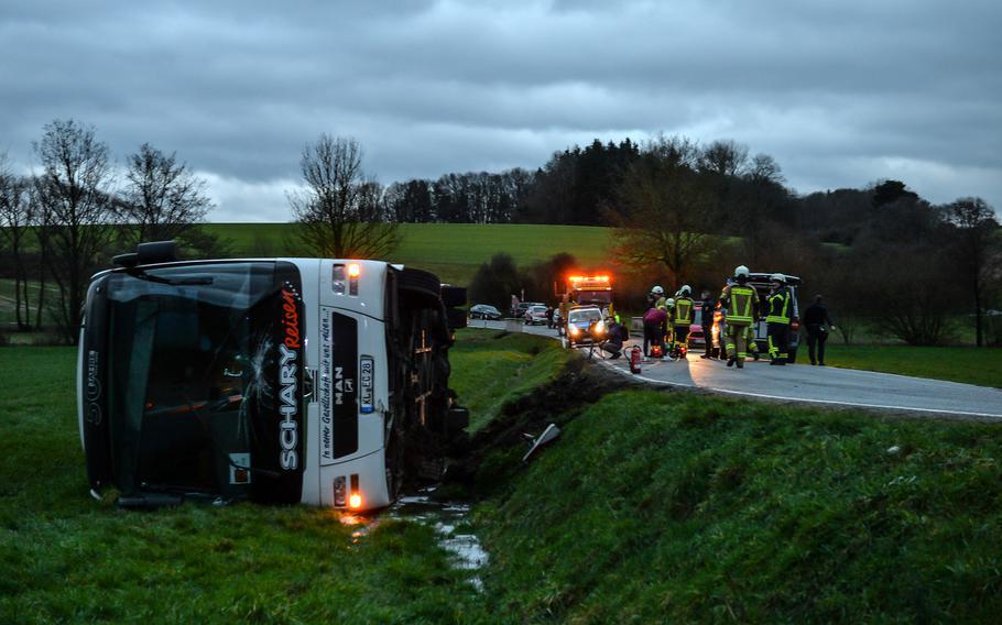 A DODEA school bus lies on the ground after heading off an embankment Friday, March 10, 2023, near Weilerbach, Germany. Sixteen students were on board, and one was taken to Landstuhl Regional Medical Center with minor injuries, authorities at the Weilerbach firehouse said at the time.