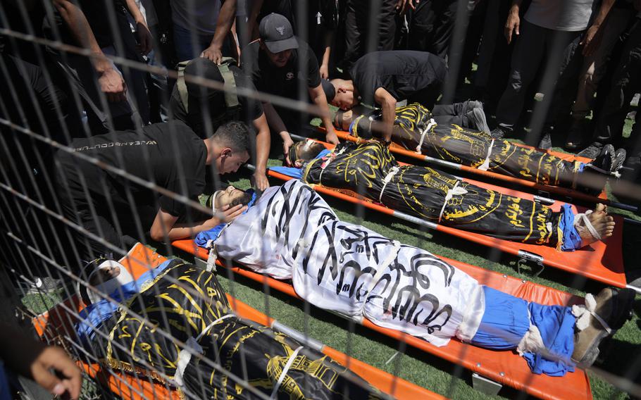 Mourners take the last look at the bodies, wrapped with Islamic Jihad flags of four Palestinians, who were killed by an Israeli airstrike late Tuesday, during their funeral in the West Bank refugee camp of Nur Shams, near Tulkarem, Wednesday, July 3, 2024. Palestinian health officials say four Palestinians were killed by an Israeli airstrike in a refugee camp in the northern West Bank late Tuesday. Israel’s military said an aircraft struck a group of militants who were planting explosives in Nur Shams refugee camp near Tulkarem. 