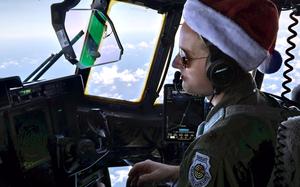 A pilot wears a Santa hat in the cockpit of a C-130J Super Hercules.