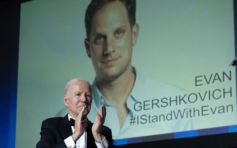 President Joe Biden gestures as an image of American journalist Evan Gershkovich appears onscreen during the White House Correspondents’ Association dinner at the Washington Hilton on April 29, 2023. The U.S. House passed a resolution Tuesday calling on Russian President Vladimir Putin to release Gershkovich and former Marine Paul Whelan, both of whom the State Department deemed “wrongfully detained.”