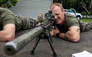 Marine Corps Staff Sgt. Alex Aman looks down the sight of an M110 Semi-Automatic Sniper System at Robertson Barracks in Darwin, Australia, April 5, 2024.