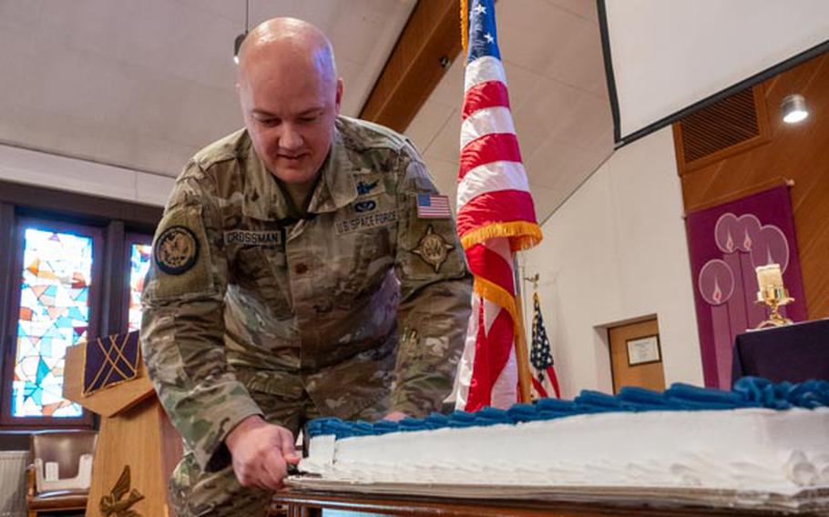 A Space Force Guardian cuts a celebratory birthday cake.