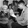 Actress Jayne Mansfield signs the cast of young Roger Perkins, one of the hundreds of fans who gathered at the Frankfurter Football Stadium, Oct. 5, 1957. The actress was there to attend the game between  Northern Area Command’s Black Knights and 10th Division Trains and seemed indefatigable signing and chatting with all her fans, be it kid, Private or General. 

Read the article on her Oct. 5, 1957 itinerary for her Frankfurt visit and see more photos here. 
https://www.stripes.com/migration/jayne-mansfield-to-tour-area-hospitals-appear-for-gis-1.migrated

Were you there? Stars and Stripes' archives staff recently digitized all images taken during Miss Mansfield 1957 trip. Although some of the images from that visit had been republished earlier, additional research by staff managed to identify additional people featured in the images with Miss Mansfield. 
If you - like young Roger here - were lucky to see Miss Mansfield dazzling smile during her Oct. 5, 1957 visit to the Frankfurt area, or recognize somebody in one of the photos, get in touch with us! Email information@stripes.com, adding "Jayne 1957" to the subject field and tell us where you were when you met Jayne. 

META TAGS: Jayne Mansfield; West Germany; celebrity; actress; press tour; movie star; entertainment; military life
