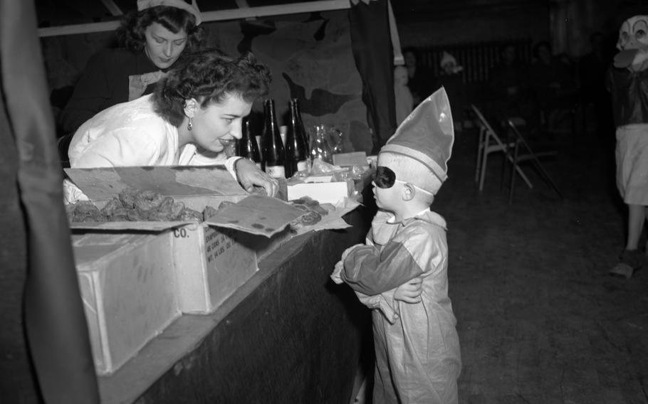 A tiny masked clown visits the concession stand to get some treats during the Halloween celebration Oct. 30, 1948 in Heidelberg.