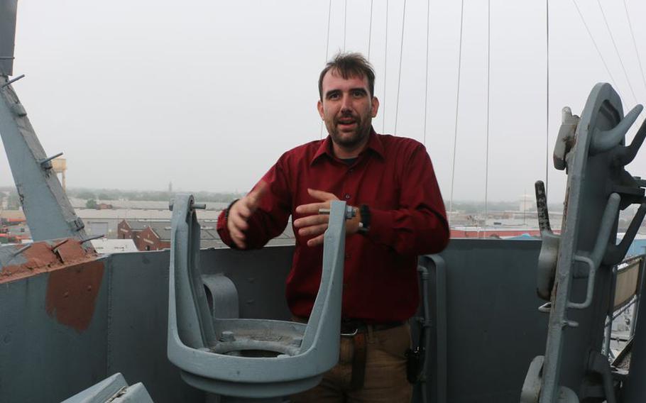 Battleship New Jersey museum curator Ryan Symanski indicates where a gyrocompass repeater can be placed during a tour of the USS New Jersey on July 13, 2021.