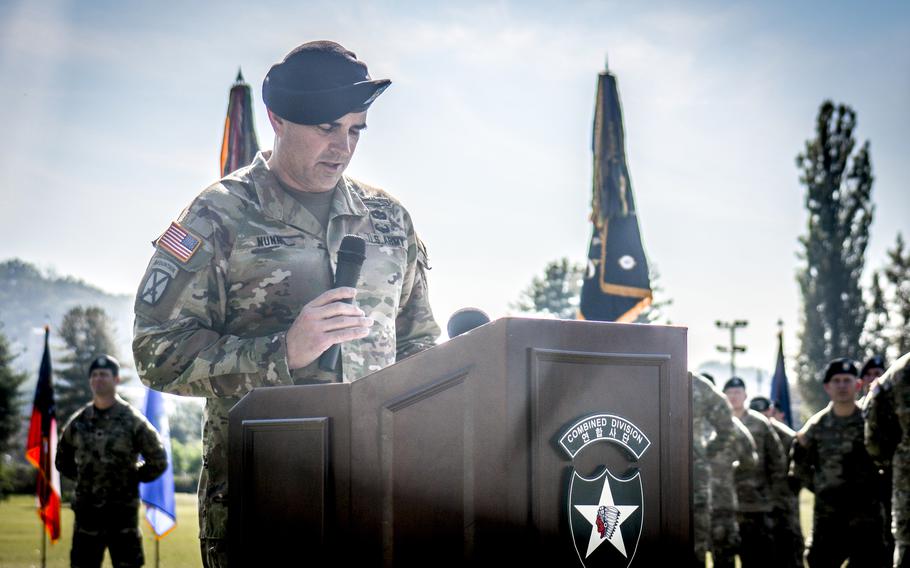 An Army colonel in uniform speaks at a lectern at Camp Casey.