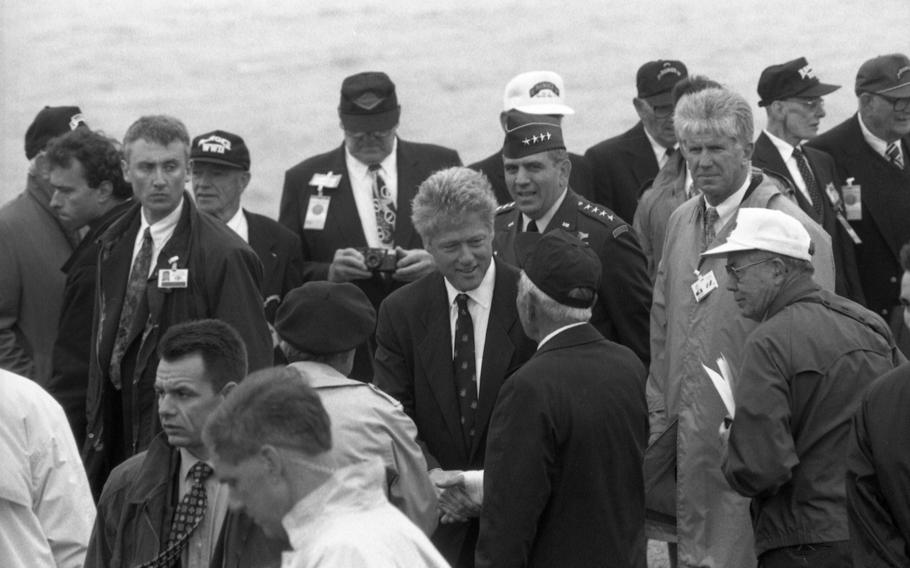 President Bill Clinton, with EUCOM commander Gen. George Joulwan behind him, talks to D-Day veterans at the ceremony commemorating the D-Day landing at Pointe du Hoc, France, near Omaha Beach.