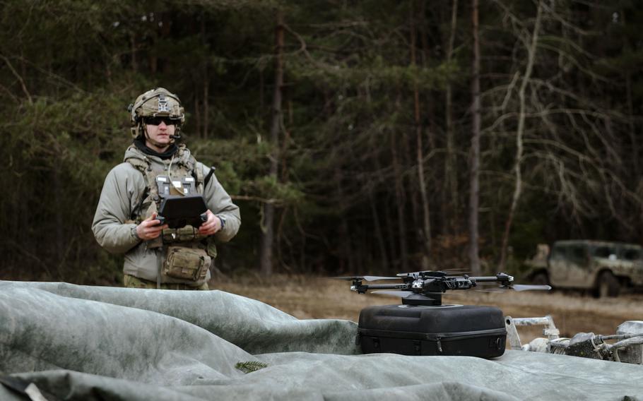 A soldier holds flight controller as he pilots a drone.