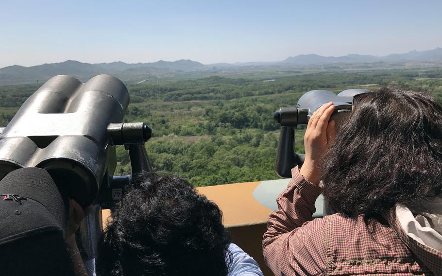 Tourists look towards North Korea across the Demilitarized Zone as propaganda blasts through loudspeakers in Paju, South Korea, in May 2017.