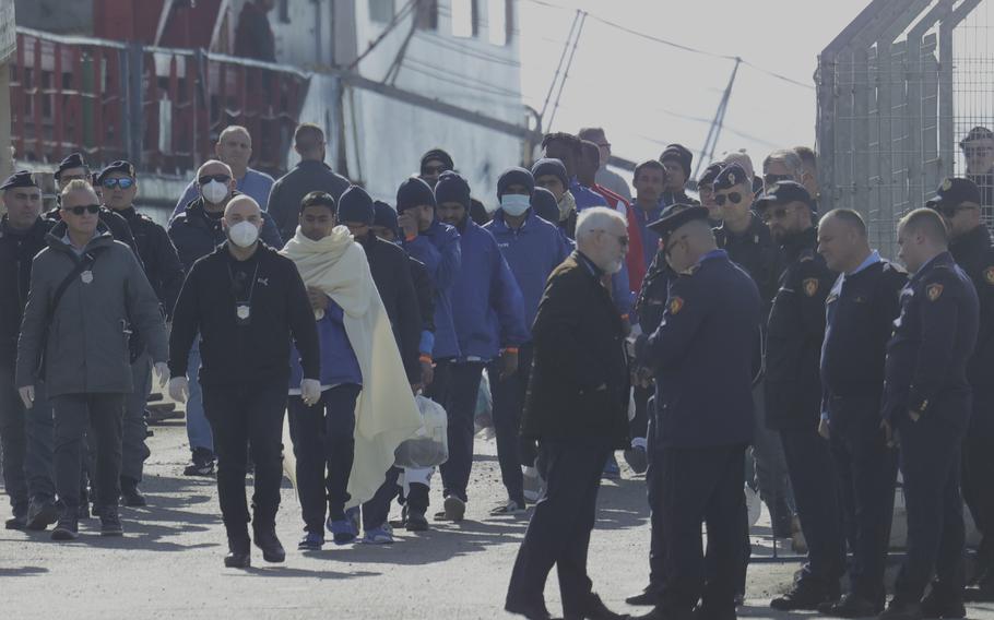 Migrants follow the authorities after their arrival