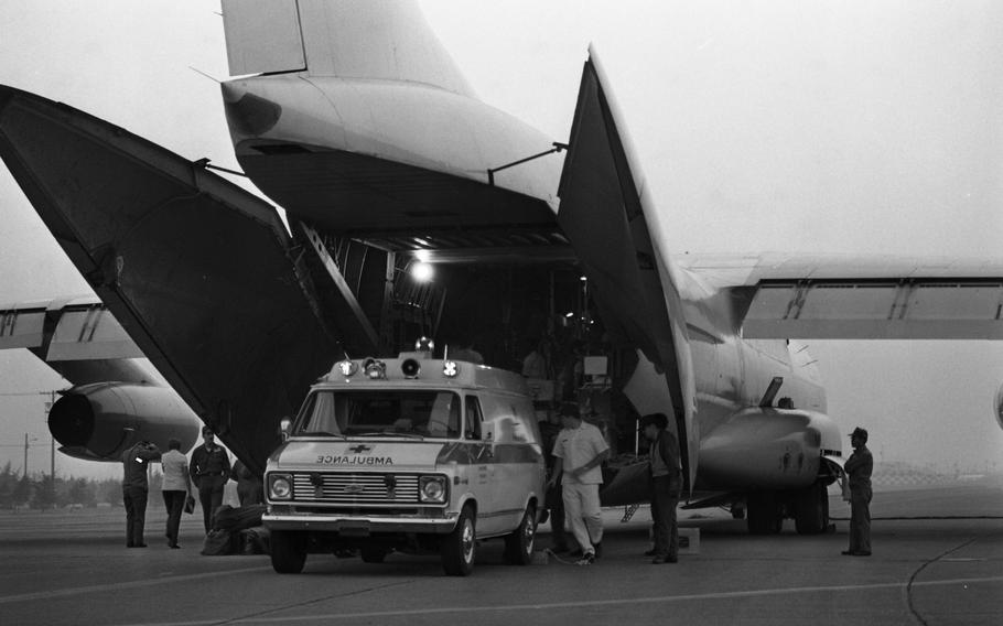 Burn victims from the Camp Fuji fire are loaded at sunset