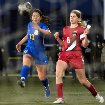 Yokota's Keiya Carlson and Nile C. Kinnick's Bree Withers chase the ball during Friday's DODEA-Japan soccer match. The teams played to a 1-1 draw.