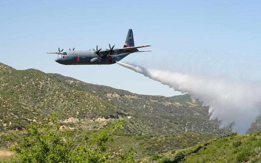 Aircraft sprays water on a forest.