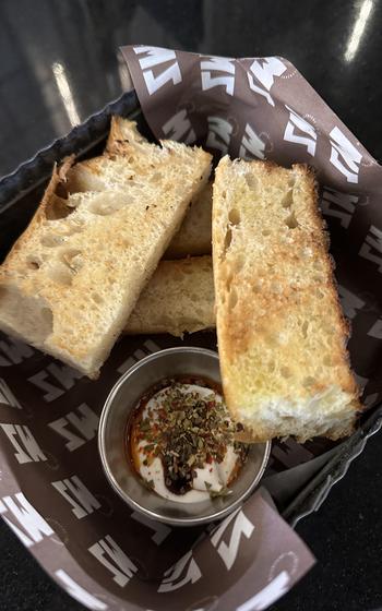 Toasted breadsticks are served with labneh, a thick yogurt, topped with olive oil and spices at Melenzane in Manama, Bahrain.