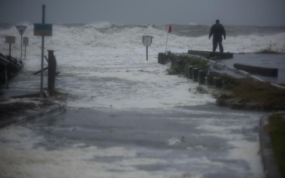 A man stands in front of storm surges in Myrtle Beach, S.C., on Sept. 30, 2022.