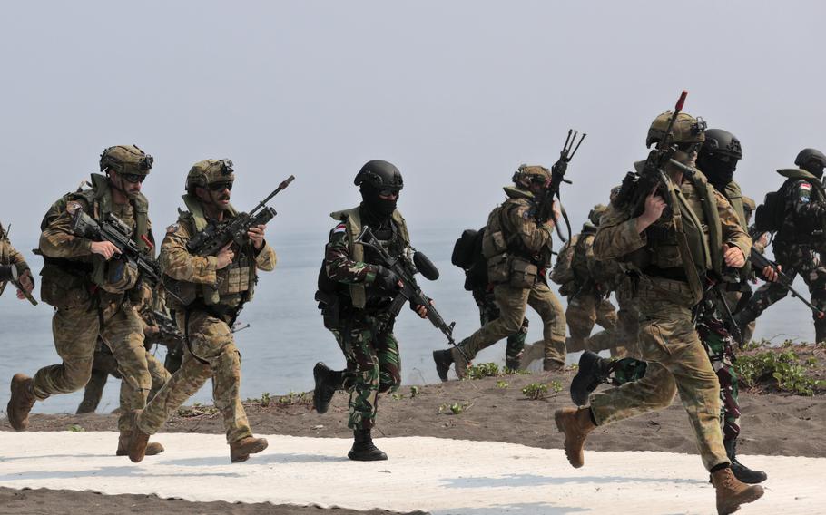 Australian soldiers and Indonesian marines run together on a beach for a joint amphibious landing exercise, Nov. 13, 2024.