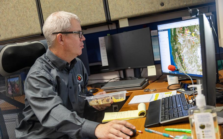 Sean Peterson looks up fire activity while eating lunch. 