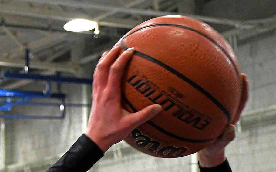 Someone holds a basketball.