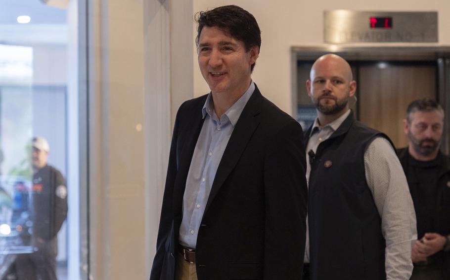 Canada Prime Minister Justin Trudeau, wearing a dark blazer and beige slacks, walks through the lobby of a hotel.