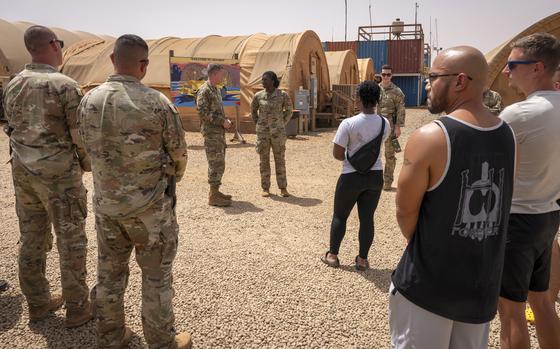 U.S. Air Force Maj. Gen. Kenneth P. Ekman speaks to military members in front of a "Welcome to Niamey" sign depicting U.S. military vehicles at Air Base 101 in Niger, May 30, 2024. 