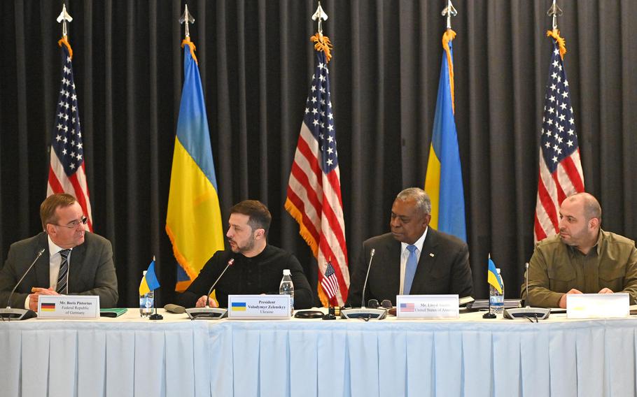 German Defense Minister Boris Pistorius, left, speaks as to his right, Ukrainian President Vlodymyr Zelenskyy, U.S. Defense Secretary Lloyd Austin and his Ukrainian counterpart Rustem Umerov turn toward him to listen.