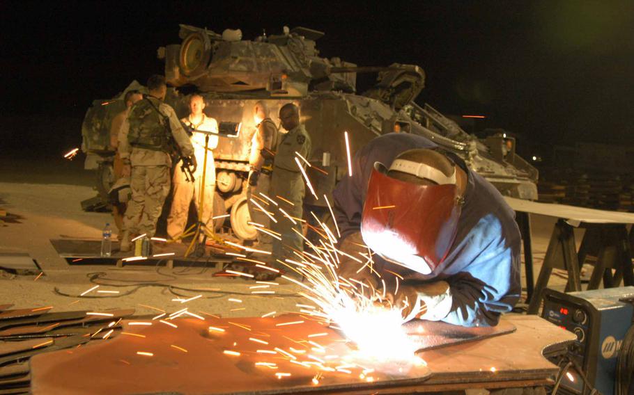 Pfc. Mark Greene of the 699th Maintenance Company working on an armored door