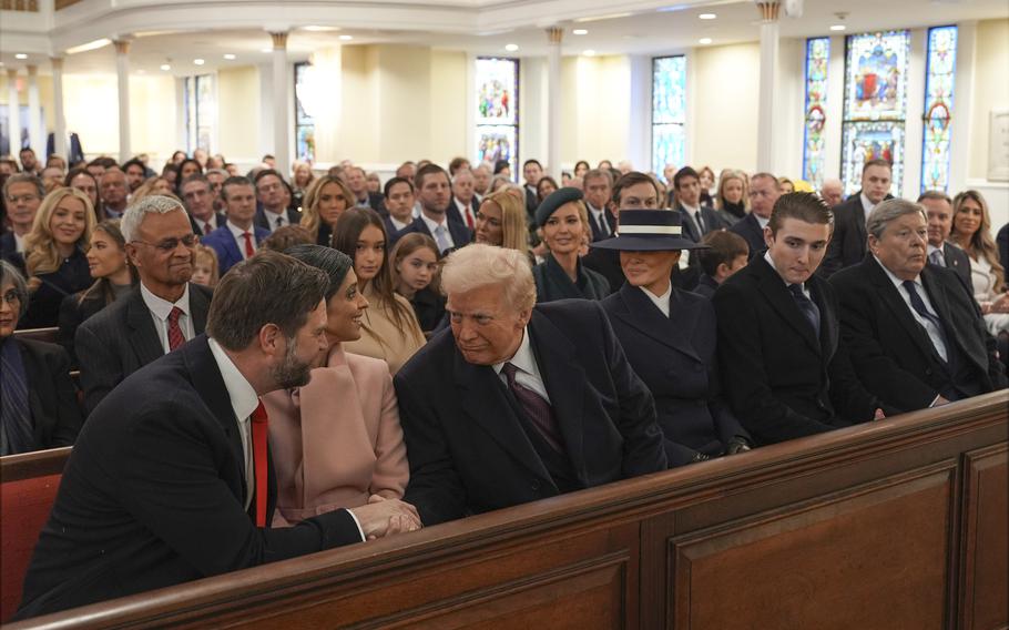 President-elect Donald Trump shakes hands with Vice President-elect JD Vance while sitting in a crowded church.